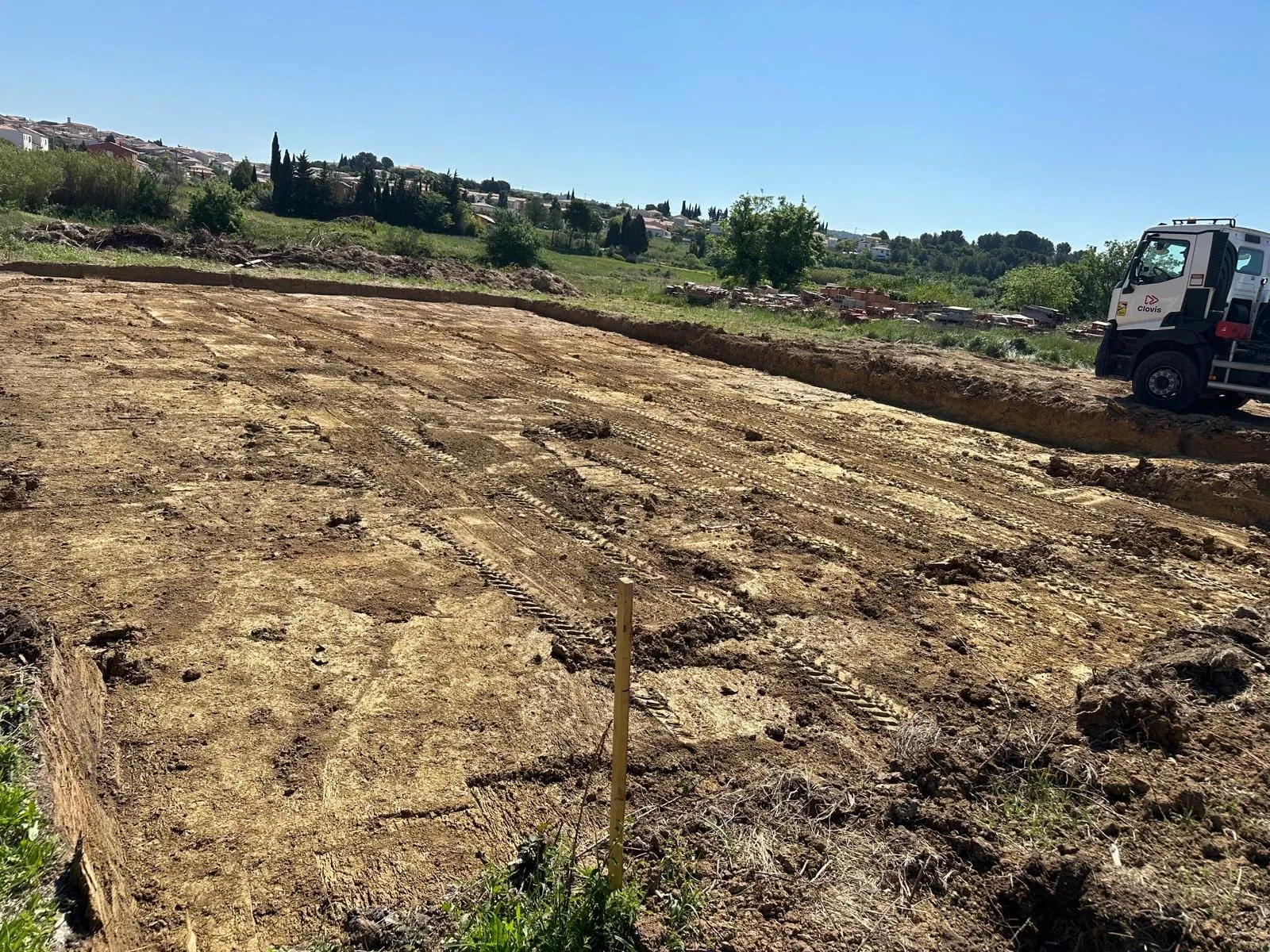 Terrain nivelé avec traces d’engins et camion de chantier