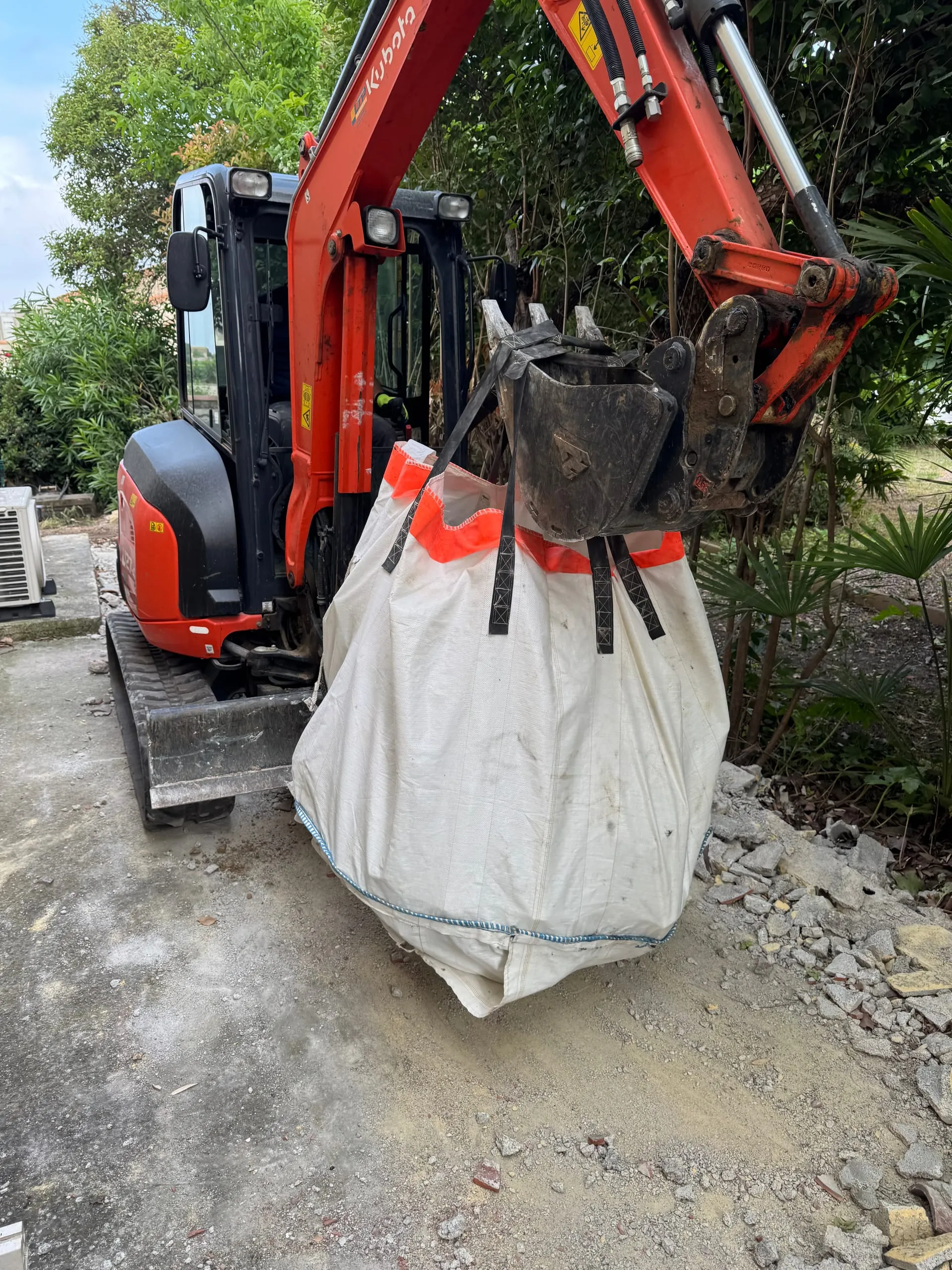 Pelle mécanique utilisée pour des travaux de terrassement et le déplacement d'un big bag.