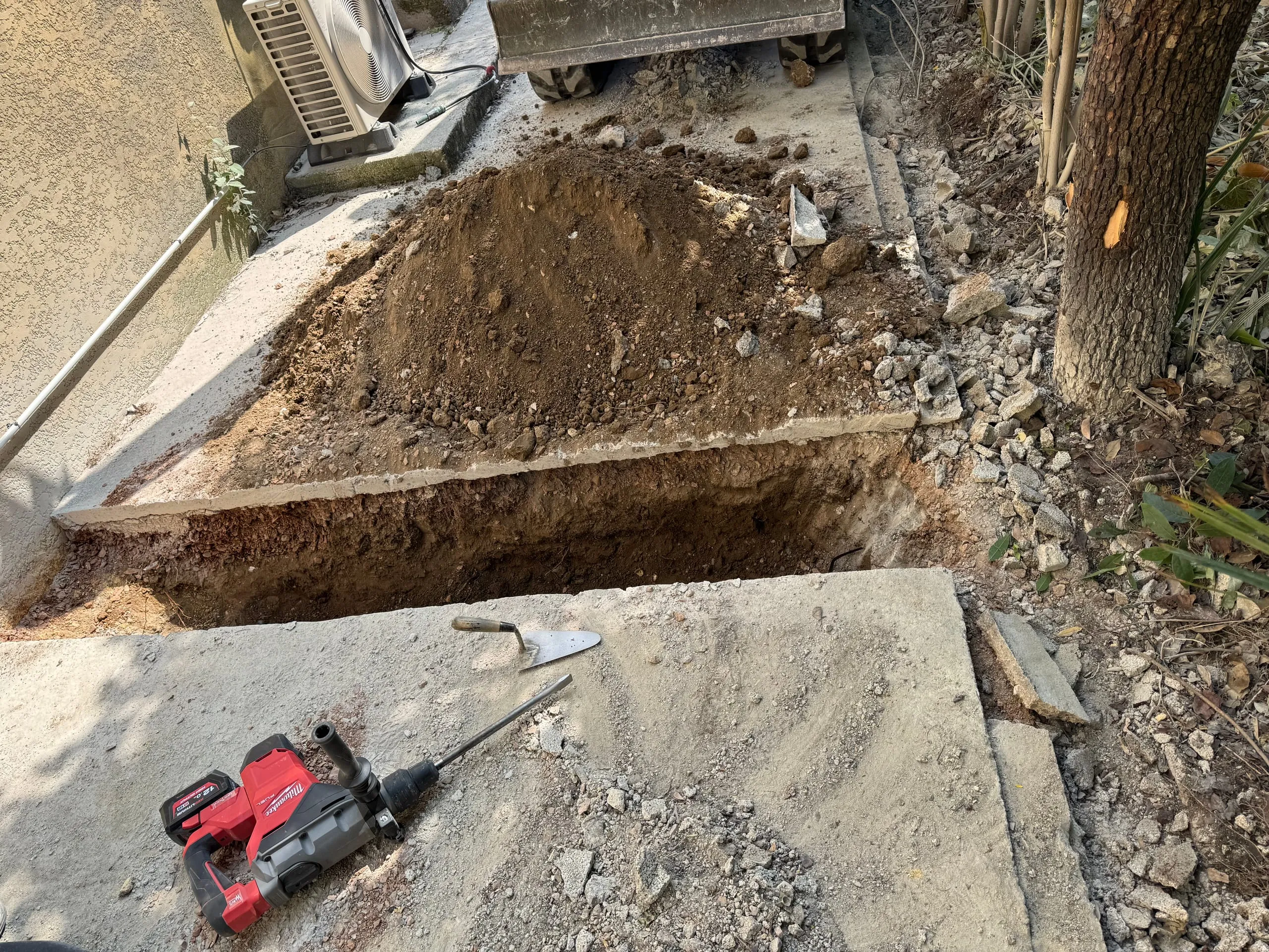 Tranchée ouverte le long d’une dalle résidentielle pour des travaux de terrassement