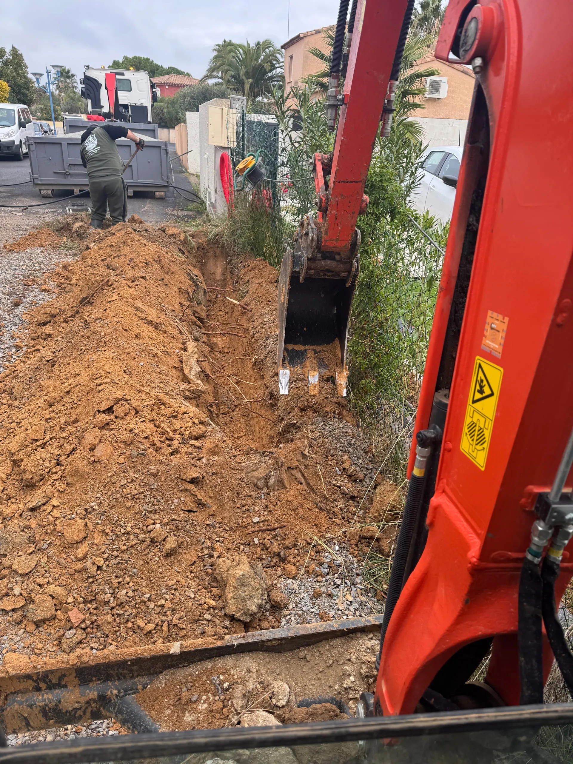Ouverture d'une tranchée avec une pelle mécanique pour des travaux de terrassement.
