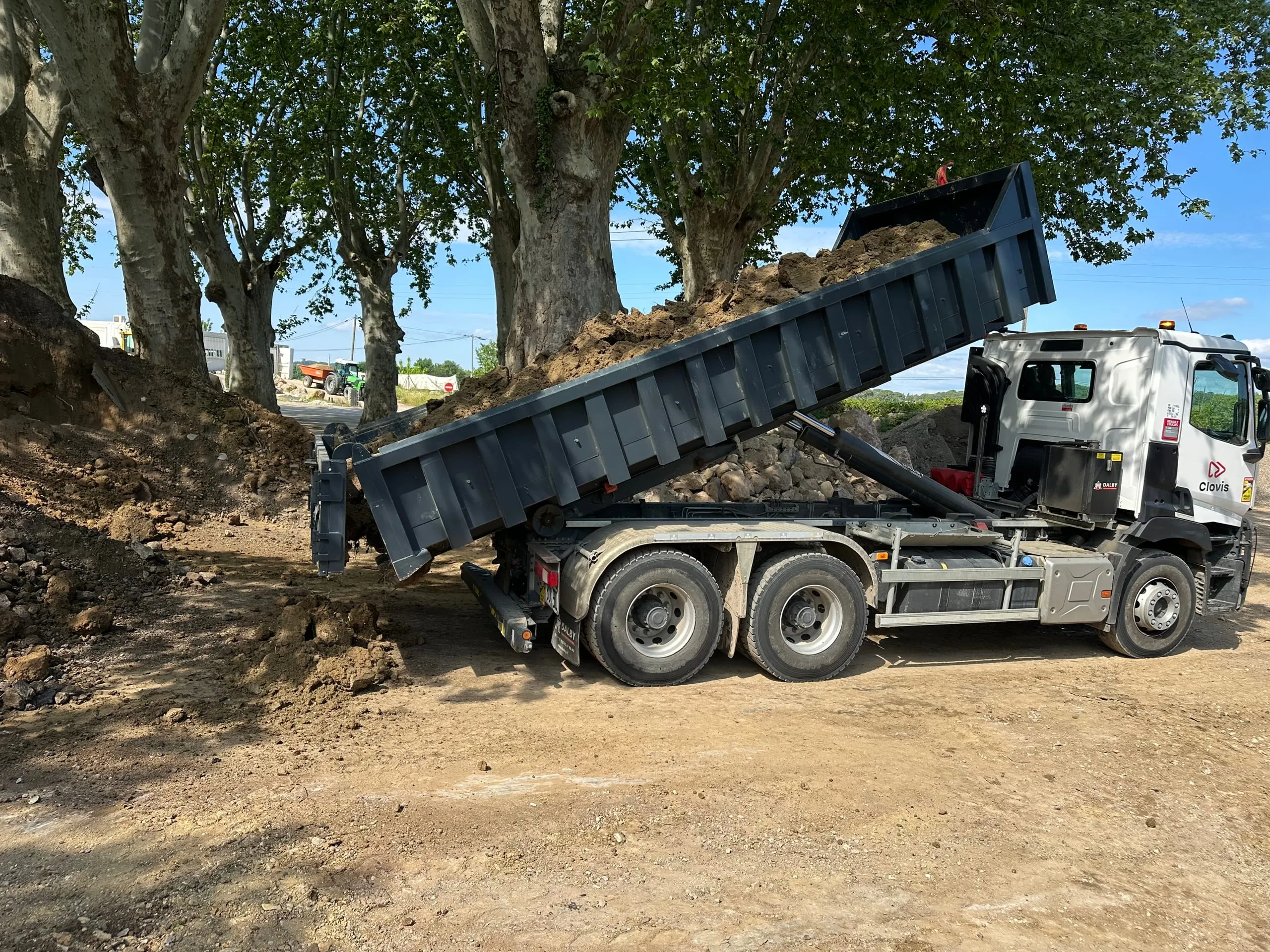 Camion-benne chargé de terre sur un chantier de terrassement.
