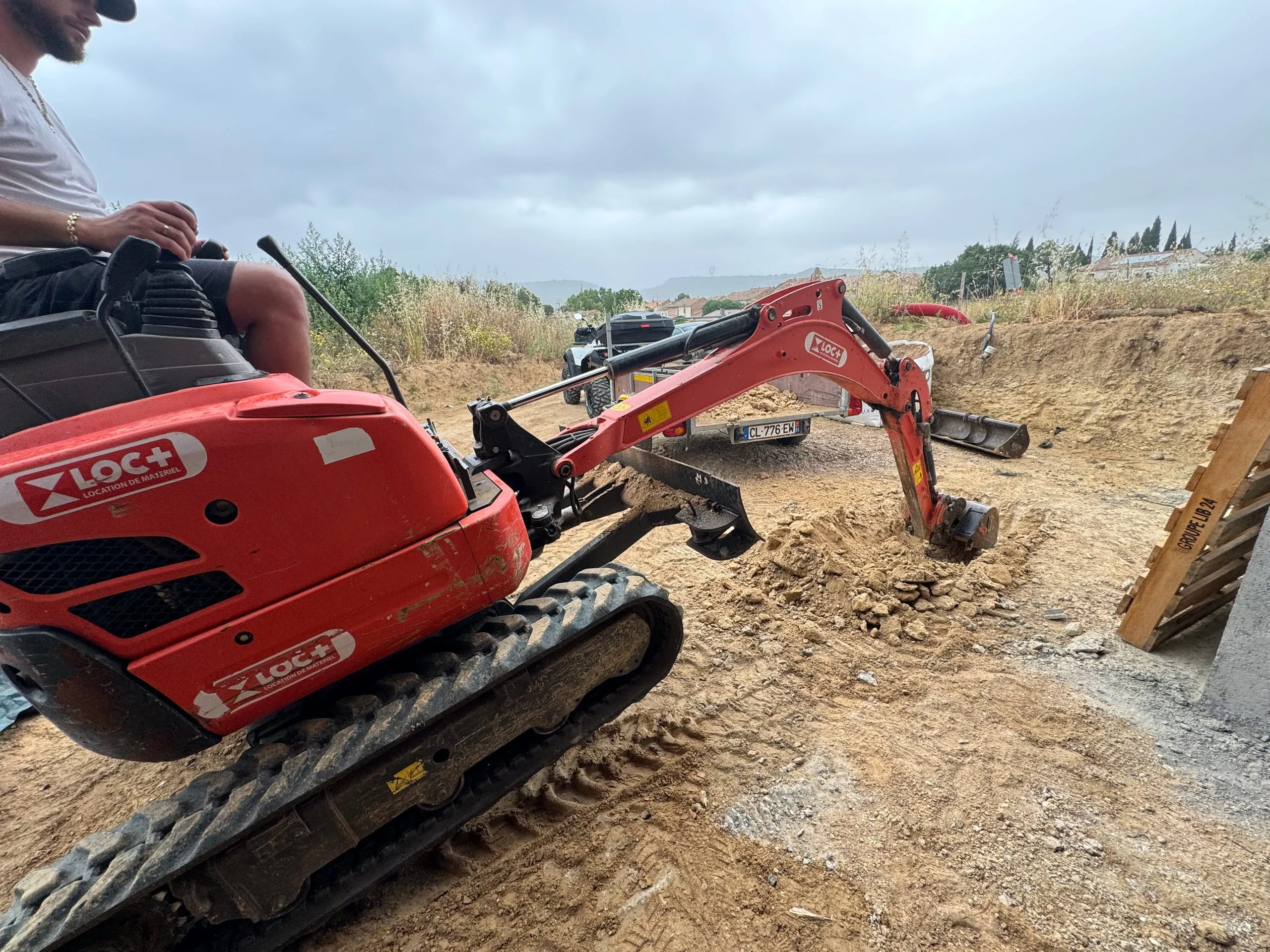 Travaux de terrassement réalisés à la mini-pelle sur un terrain en cours d'excavation.