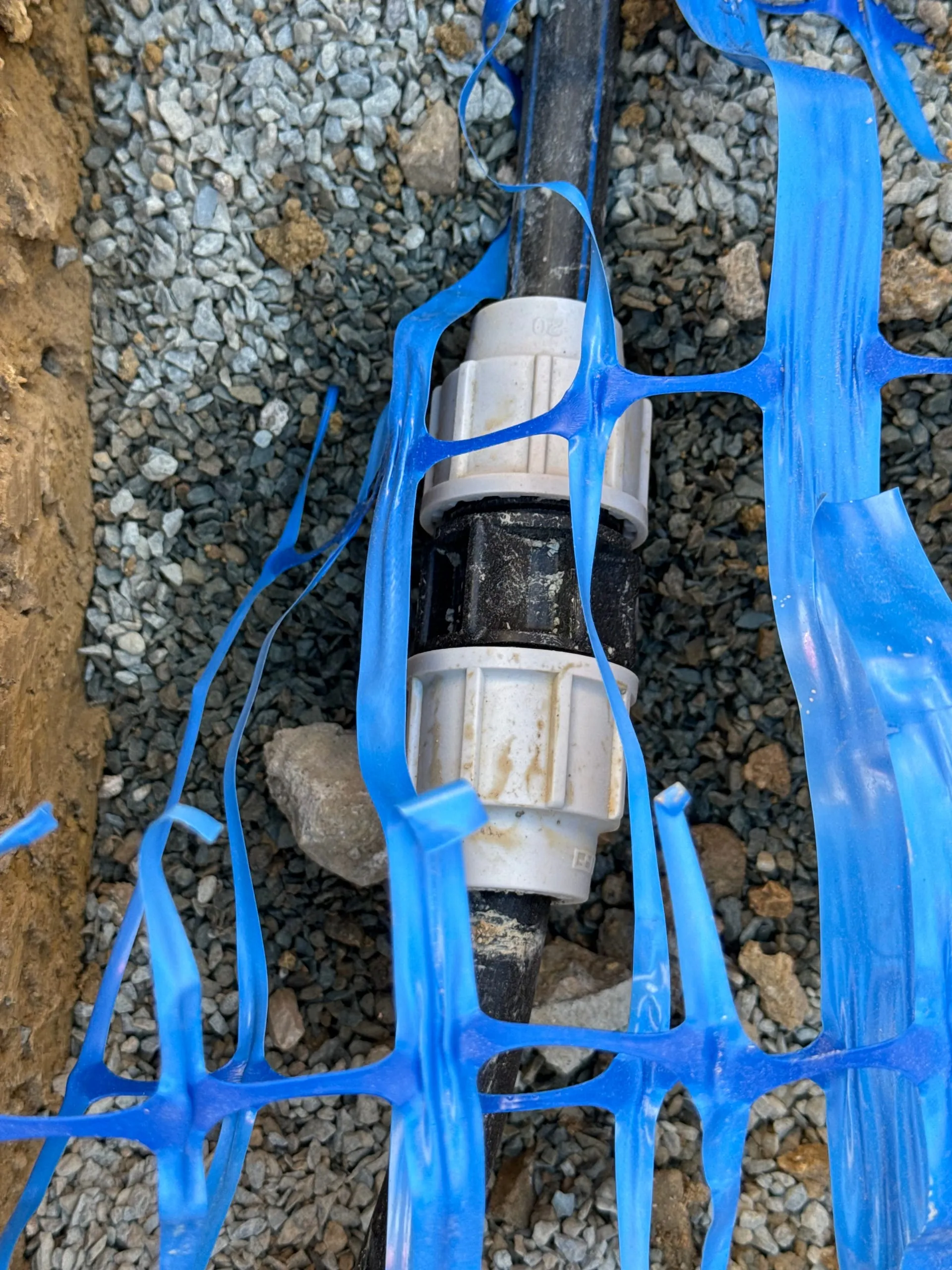 Raccord de canalisation d’eau potable posé dans une tranchée de gravier